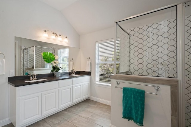 306 Gulfton St, Austin, TX 78738 - bathroom featuring tiled shower, double vanity, and lofted ceiling