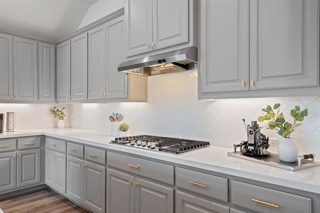 306 Gulfton St, Austin, TX 78738 - kitchen featuring gray cabinets, under cabinet range hood, stainless steel gas cooktop, light countertops, and lofted ceiling