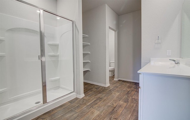 5912 Berriweather Dr, Austin, TX 78724 - bathroom with wood finished floors, a shower stall, vanity, toilet, and baseboards