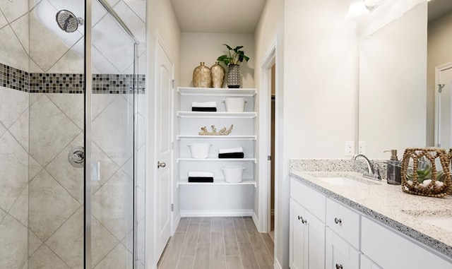 737 Drystone Trl, Liberty Hill, TX 78642 - full bath with a sink, wood finish floors, double vanity, and a stall shower