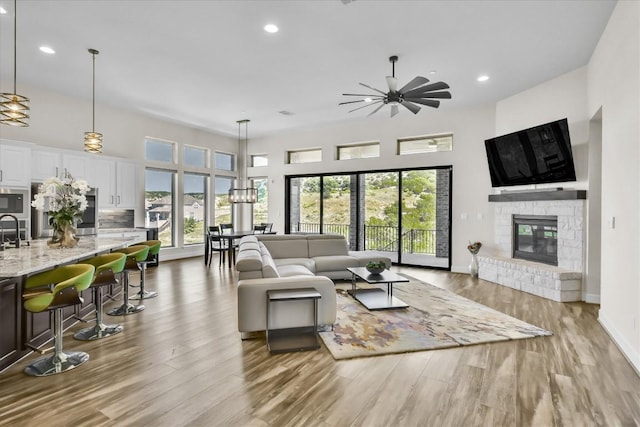 6101 Fadden Rd, Austin, TX 78738 - living area with a fireplace, wood finished floors, a ceiling fan, recessed lighting, and baseboards