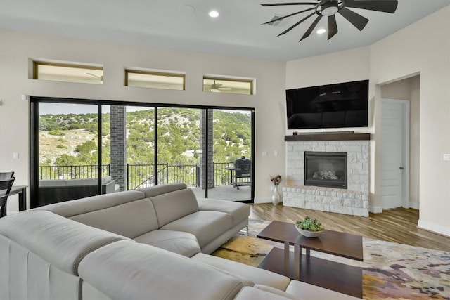 6101 Fadden Rd, Austin, TX 78738 - living room with a ceiling fan, a stone fireplace, baseboards, recessed lighting, and wood finished floors