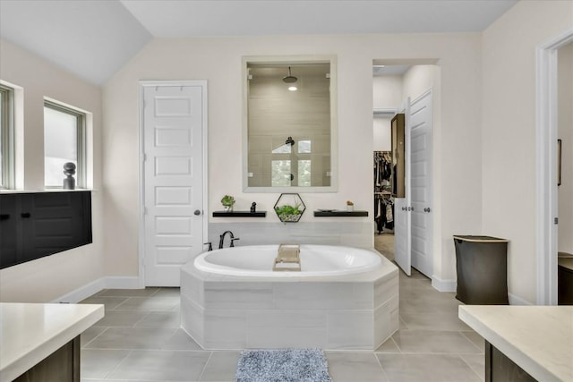 6101 Fadden Rd, Austin, TX 78738 - full bath with a garden tub, tile patterned flooring, baseboards, lofted ceiling, and a walk in closet