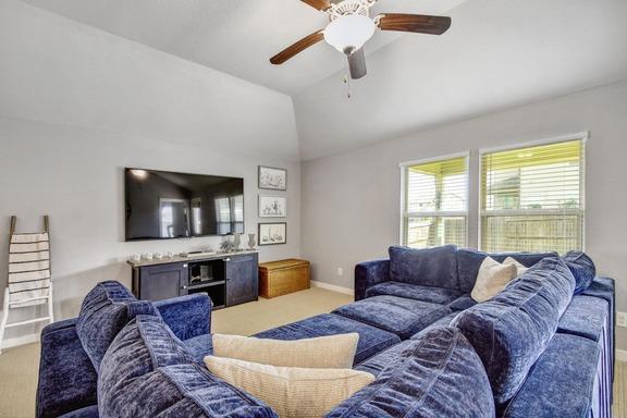 5907 Akin Run, San Antonio, TX 78261 - living room featuring a ceiling fan, lofted ceiling, baseboards, and light colored carpet