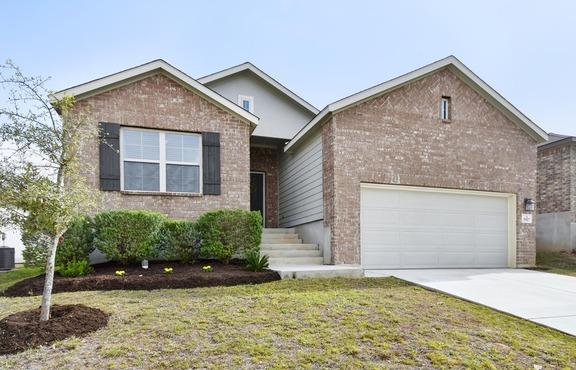 ranch-style house featuring a front yard, brick siding, driveway, and an attached garage
