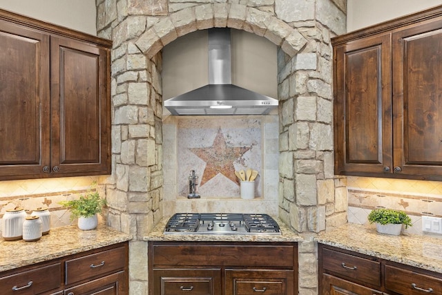 201 Aldea St, Georgetown, TX 78633 - kitchen with wall chimney range hood, stainless steel gas cooktop, tasteful backsplash, and dark brown cabinets