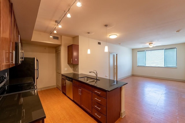 3016 Guadalupe St Unit 212, Austin, TX 78705 - kitchen with stainless steel appliances, dark countertops, a peninsula, track lighting, and brown cabinets