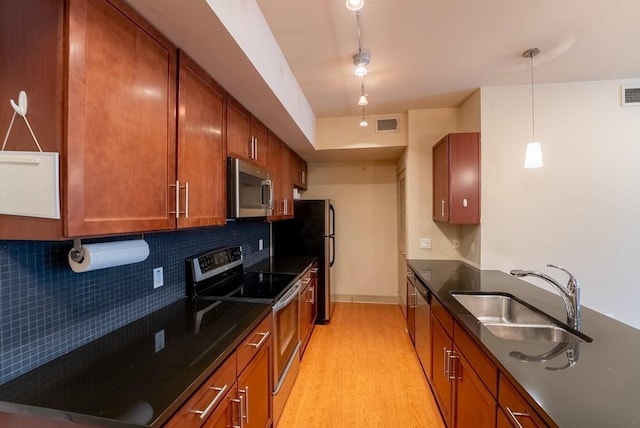 3016 Guadalupe St Unit 212, Austin, TX 78705 - kitchen featuring appliances with stainless steel finishes, light wood-style floors, backsplash, and brown cabinets