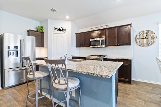 215 Whipporwill Ln, San Marcos, TX 78666 - kitchen with stainless steel appliances, a sink, dark brown cabinets, backsplash, and recessed lighting