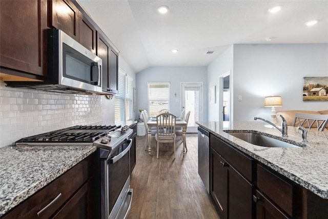 215 Whipporwill Ln, San Marcos, TX 78666 - kitchen with stainless steel appliances, a sink, lofted ceiling, dark wood finished floors, and backsplash