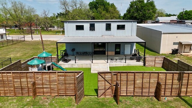 617 Main St, Lexington, TX 78947 - rear view of house featuring a playground, a fenced backyard, and a patio area