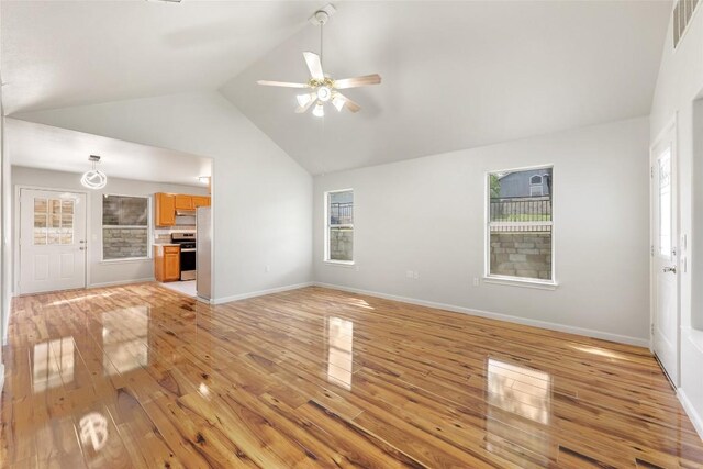 unfurnished living room featuring visible vents, baseboards, light wood finished floors, a ceiling fan, and high vaulted ceiling
