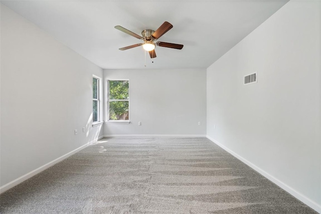 unfurnished room with baseboards, visible vents, a ceiling fan, and carpet flooring