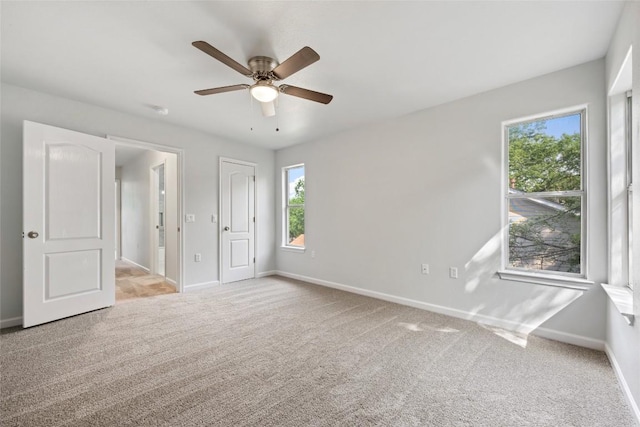 unfurnished bedroom with carpet, a ceiling fan, and baseboards