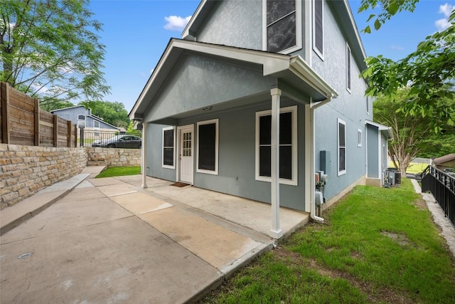 back of property featuring stucco siding, a patio area, a yard, and a fenced backyard