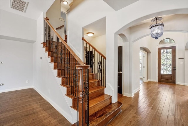 11609 Woodland Hills Trl, Austin, TX 78732 - foyer featuring hardwood / wood-style flooring, a chandelier, stairway, and arched walkways