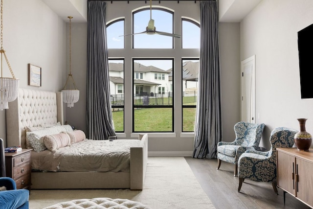 4525 Via Roma Pass, Leander, TX 78641 - bedroom featuring light wood-style floors, multiple windows, and a high ceiling