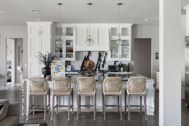 4525 Via Roma Pass, Leander, TX 78641 - kitchen with a sink, a kitchen island with sink, decorative light fixtures, and a breakfast bar area
