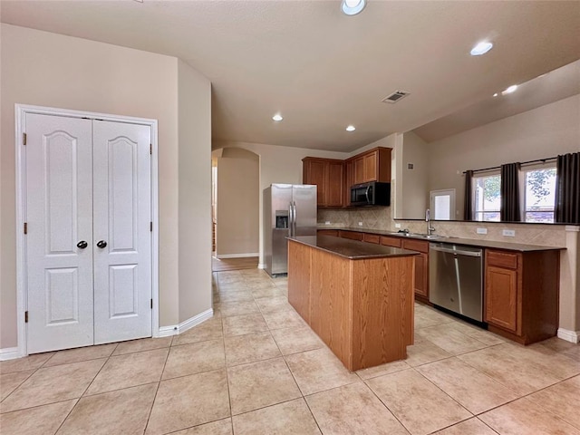 613 Arrowhead Trl, Cedar Park, TX 78613 - kitchen with appliances with stainless steel finishes, a sink, arched walkways, backsplash, and a center island