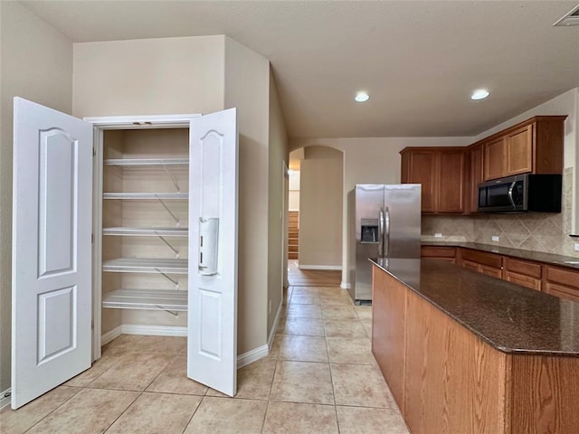 613 Arrowhead Trl, Cedar Park, TX 78613 - kitchen featuring appliances with stainless steel finishes, arched walkways, light tile patterned flooring, decorative backsplash, and recessed lighting