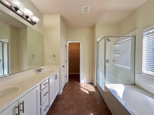 613 Arrowhead Trl, Cedar Park, TX 78613 - full bath with a stall shower, double vanity, a bath, tile patterned flooring, and a walk in closet