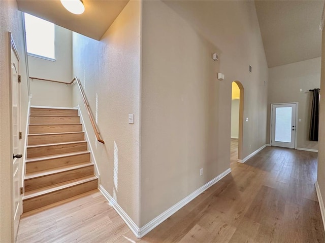 613 Arrowhead Trl, Cedar Park, TX 78613 - stairway featuring arched walkways, wood finished floors, baseboards, and high vaulted ceiling