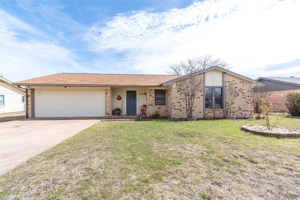 1906 Nimitz Dr, Killeen, TX 76543 - view of front of property with a garage, brick siding, driveway, and a front lawn