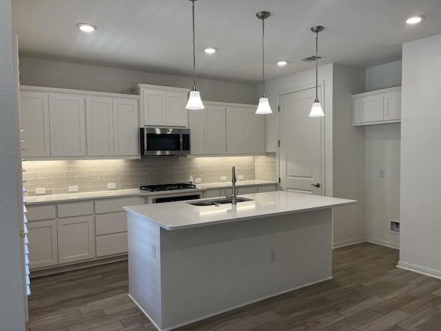 19316 Fernando Trl, Austin, TX 78738 - kitchen with a sink, gas stovetop, dark wood finished floors, stainless steel microwave, and white cabinetry