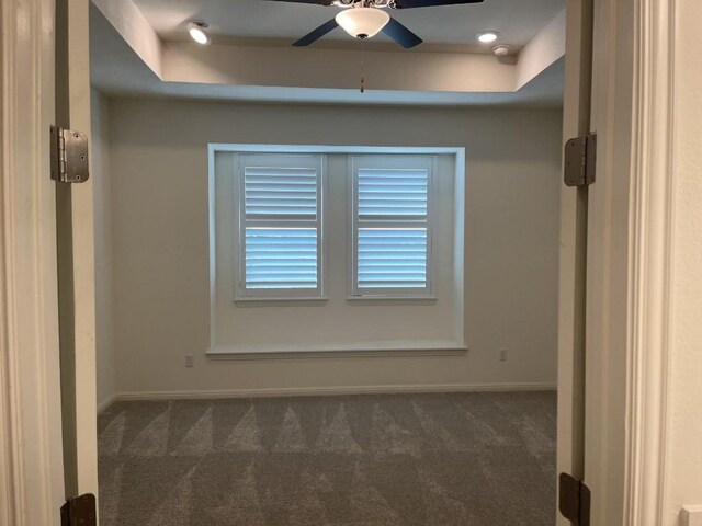 19316 Fernando Trl, Austin, TX 78738 - empty room featuring dark carpet, baseboards, a ceiling fan, and a tray ceiling