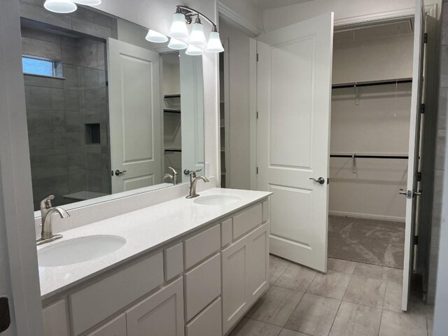 19316 Fernando Trl, Austin, TX 78738 - bathroom featuring tiled shower, double vanity, a sink, and a walk in closet