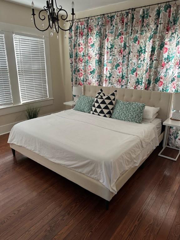 900 W Lynn St, Austin, TX 78703 - bedroom featuring wood finished floors and a chandelier