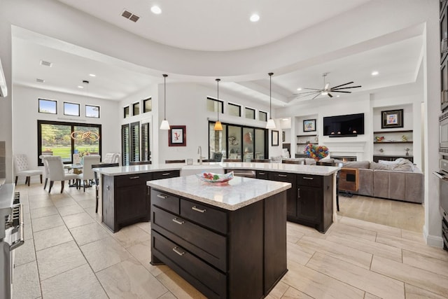 17301 Avion Dr, Dripping Springs, TX 78620 - kitchen featuring a spacious island, open floor plan, ceiling fan, dark brown cabinetry, and recessed lighting