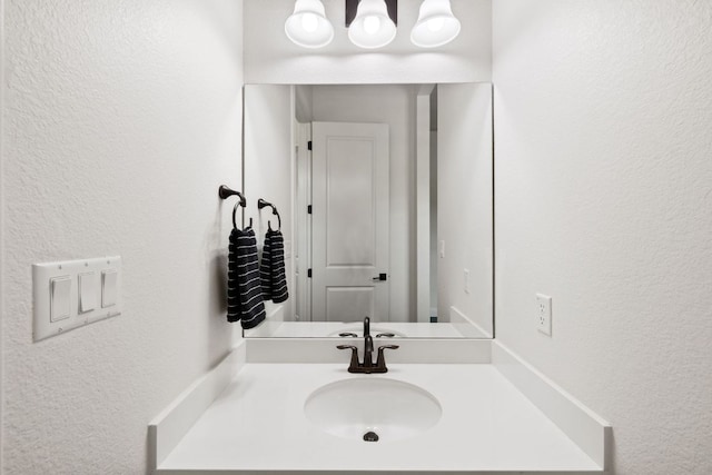 bathroom with vanity and a textured wall