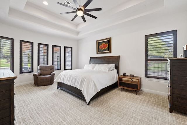 bedroom featuring carpet, visible vents, a tray ceiling, and baseboards