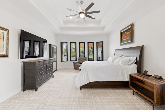 bedroom with baseboards, a ceiling fan, a tray ceiling, recessed lighting, and light carpet