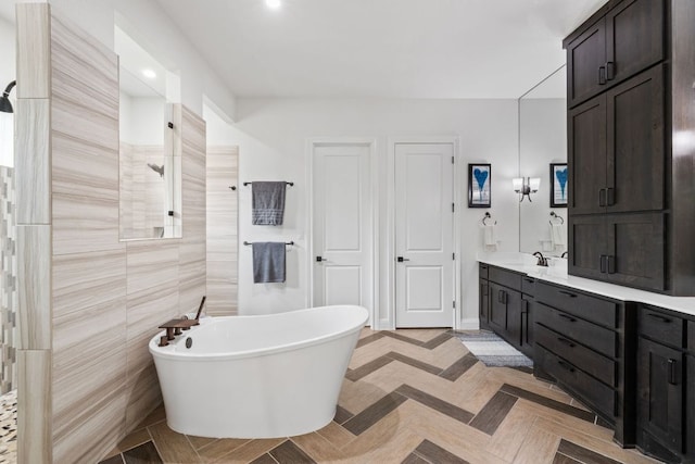 bathroom with walk in shower, a freestanding bath, and vanity