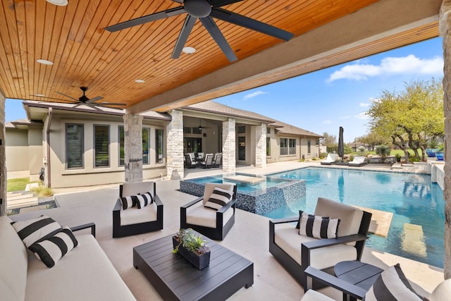 view of swimming pool featuring an outdoor living space, a pool with connected hot tub, and a patio area