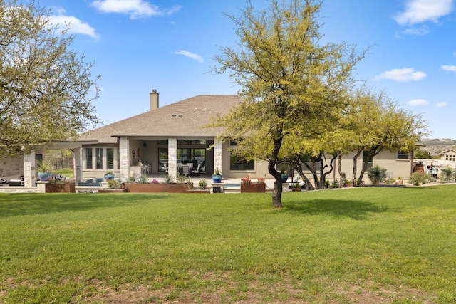 back of house featuring a patio, a lawn, and a chimney