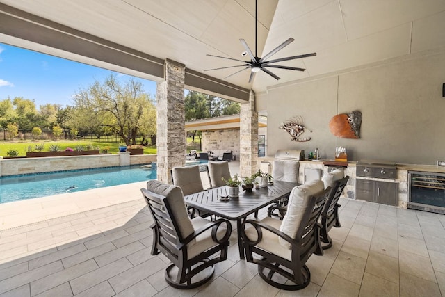 view of patio / terrace featuring an outdoor pool, grilling area, exterior kitchen, and wine cooler
