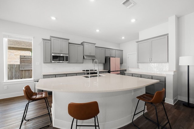 134 Soft Elm Dr, Buda, TX 78610 - kitchen featuring gray cabinetry, a sink, stainless steel microwave, freestanding refrigerator, and recessed lighting