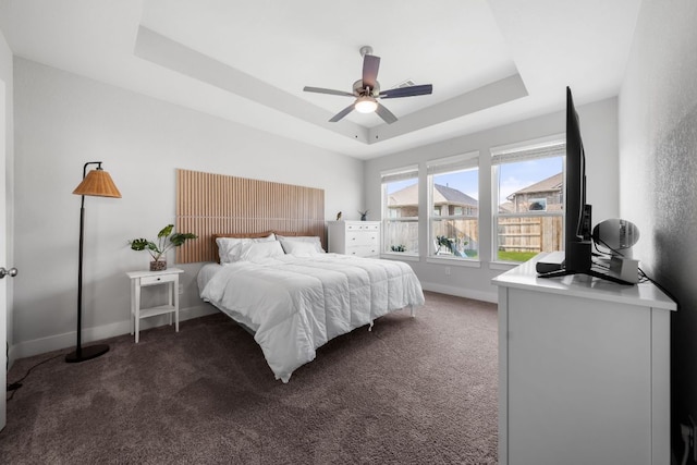 134 Soft Elm Dr, Buda, TX 78610 - carpeted bedroom featuring a tray ceiling, baseboards, and ceiling fan