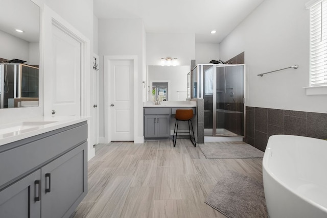 134 Soft Elm Dr, Buda, TX 78610 - bathroom with a shower stall, two vanities, a freestanding bath, and tile walls