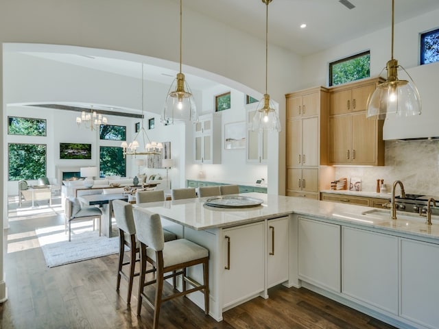 1614 Bruton Springs Rd, Austin, TX 78733 - kitchen with a chandelier, dark wood-type flooring, light stone counters, a towering ceiling, and recessed lighting