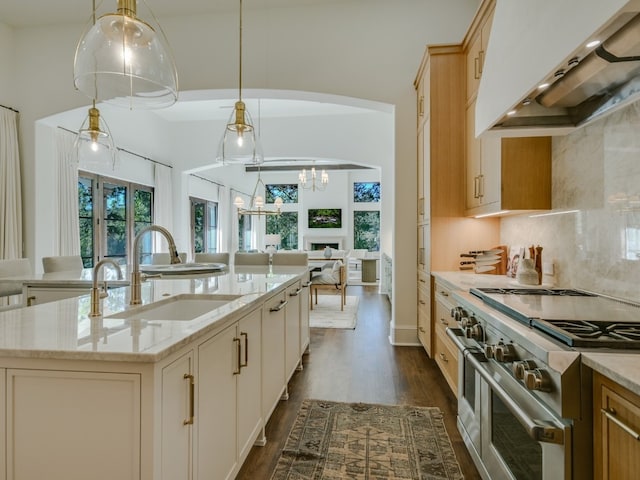 1614 Bruton Springs Rd, Austin, TX 78733 - kitchen featuring extractor fan, double oven range, a sink, dark wood finished floors, and light stone counters