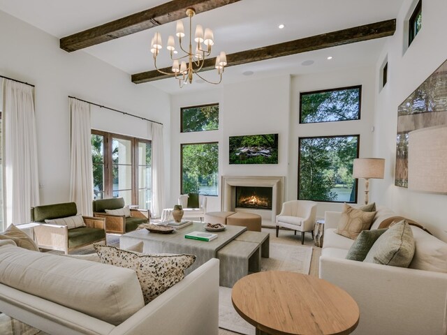 1614 Bruton Springs Rd, Austin, TX 78733 - living area with healthy amount of natural light, a lit fireplace, a high ceiling, beam ceiling, and a chandelier