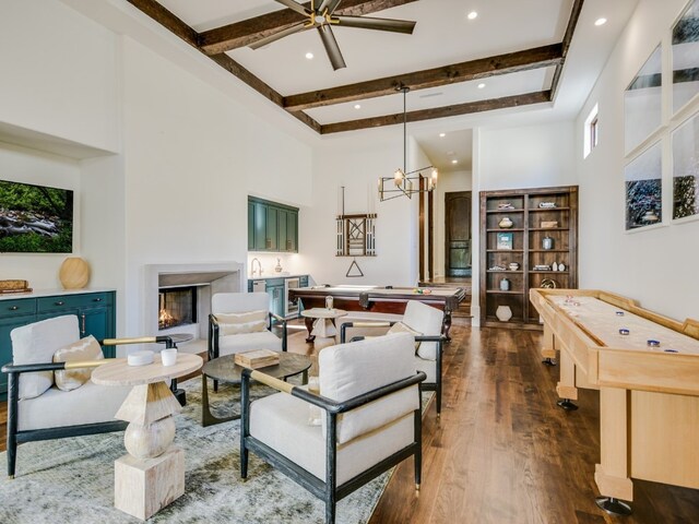 1614 Bruton Springs Rd, Austin, TX 78733 - living room featuring a high ceiling, dark wood-style floors, a lit fireplace, beamed ceiling, and a chandelier