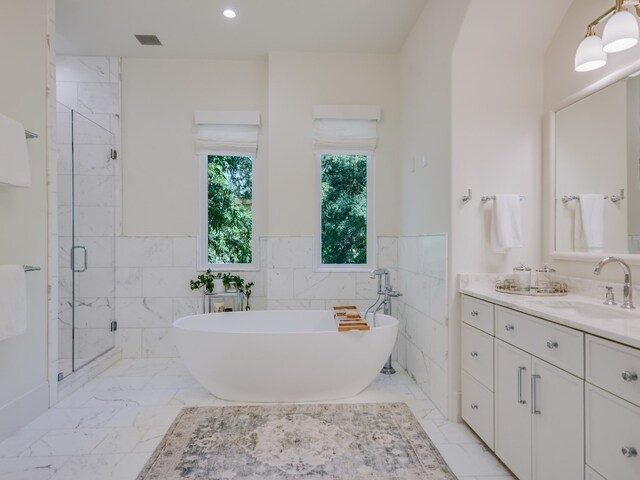 1614 Bruton Springs Rd, Austin, TX 78733 - full bath with a shower stall, a freestanding bath, vanity, marble finish flooring, and tile walls