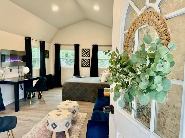 bedroom with vaulted ceiling and wood finished floors