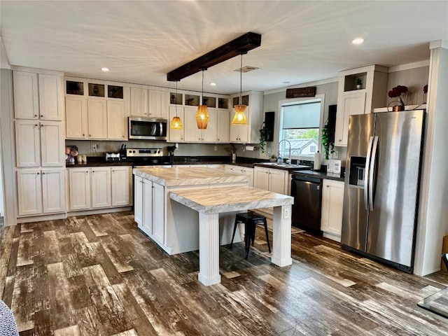 kitchen featuring a sink, stainless steel appliances, dark wood finished floors, a kitchen island, and recessed lighting