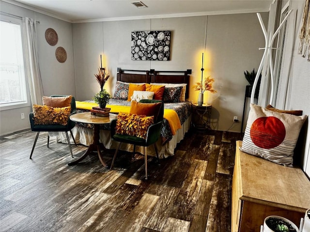 bedroom featuring ornamental molding, wood finished floors, and visible vents